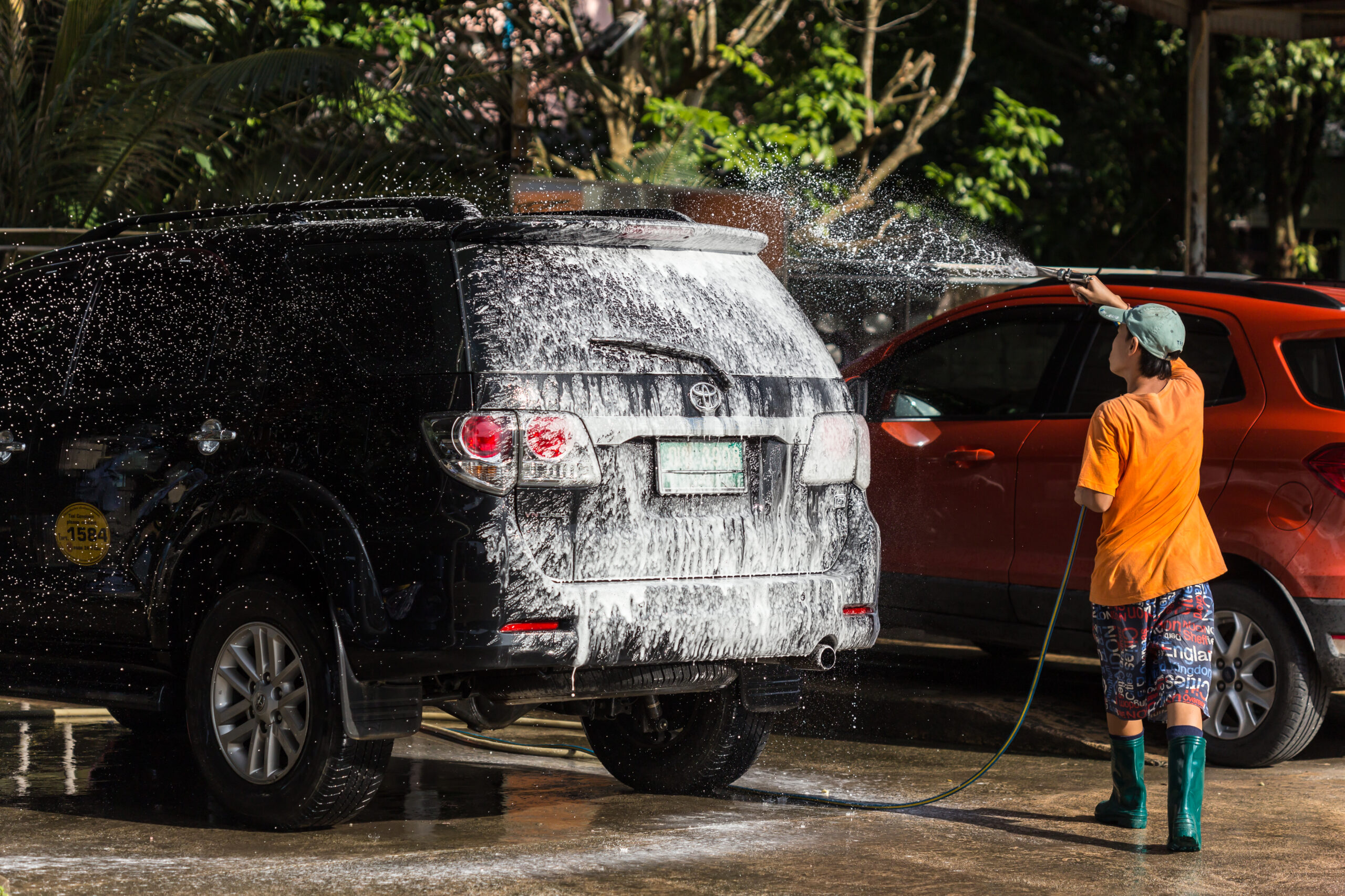 a man spraying pressure washer for car wash in car care shop